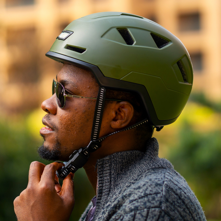 man buckling fidlock strap on xnito helmet and telling his friend where he bought his sweater