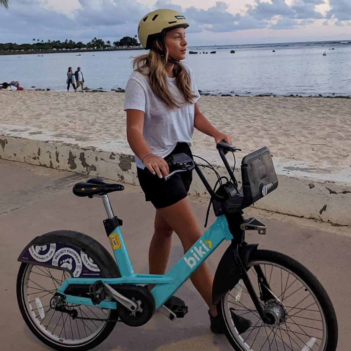 woman on bike with wearing an xnito ebike helmet holding an ugly bike