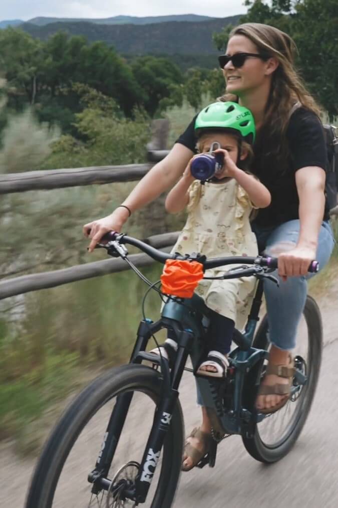 woman and child on bike with mountains