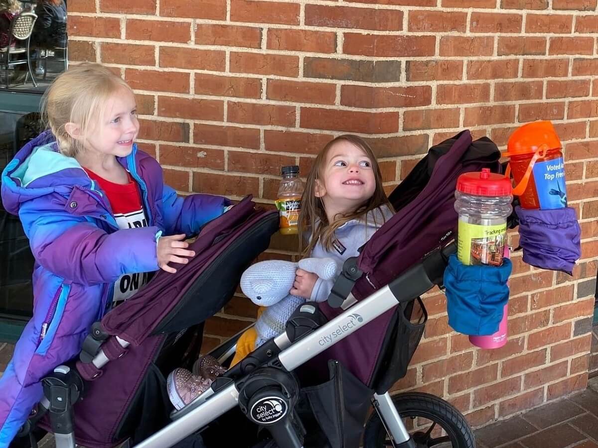 kids on stroller with multiple drinks in stroller cup holder