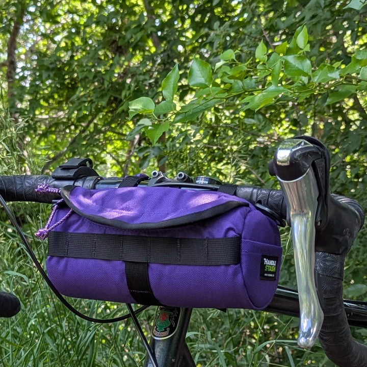 purple handlebar bag on gravel bike in the woods