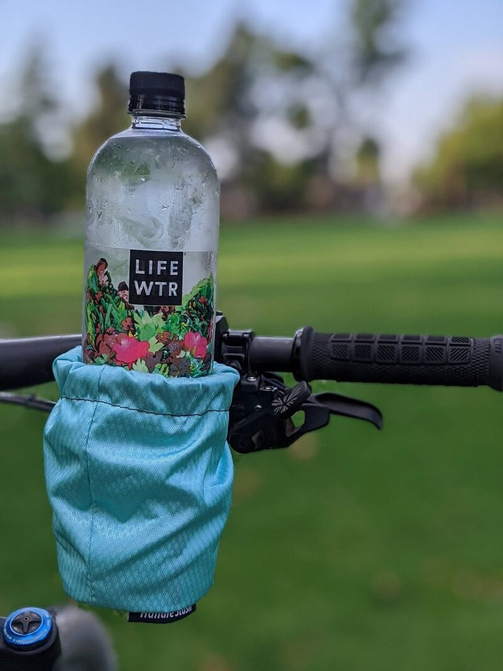 HandleStash bike cup holder in Influencer Blue on flat handlebars. 