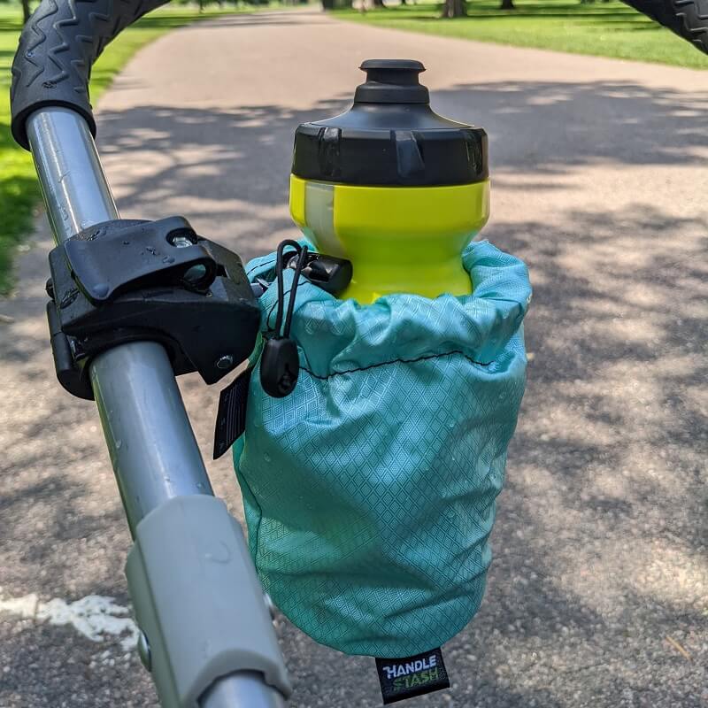 teal HandleStash stroller cup holder on stroller with a water bottle